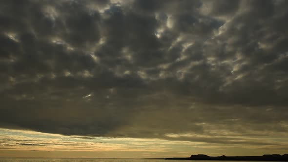 Time lapse of clouds moving through dramatic sky at sunset