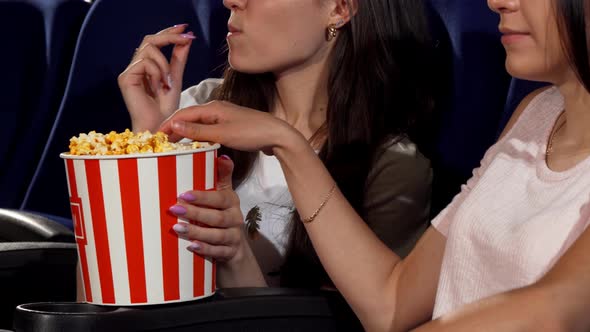 Cheerful Female Friends Eating Popcorn at the Cinema