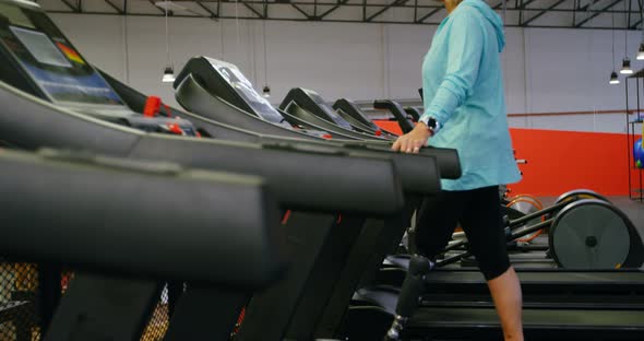 Senior woman using virtual reality headset on treadmill