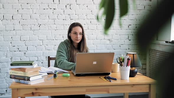 Serious White Girl Student in Glasses Typing on Laptop Preparing Course Work