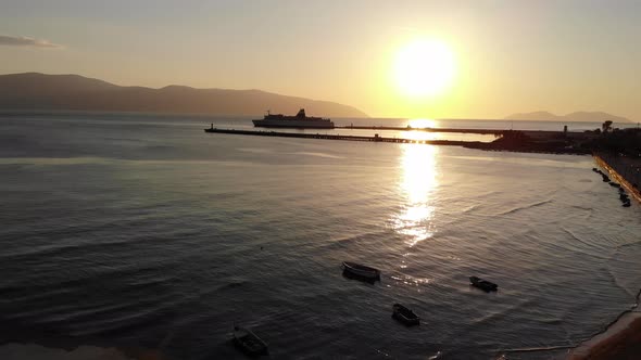 Silhouette of a Huge Cruise Ship and Many Fishing Boats with Golden Sunset