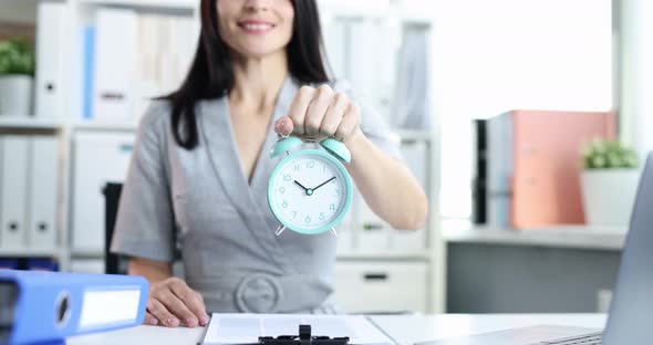 Smiling Businesswoman Holds Out Alarm Clock for Ten in Morning  Movie