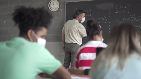 Teacher and Teenager Students with Face Mask Learning in the High School Lecture