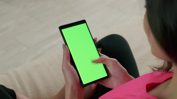 Close Up View of Woman Holding Chroma Key Green Screen Smartphone Watching Content and Touching or