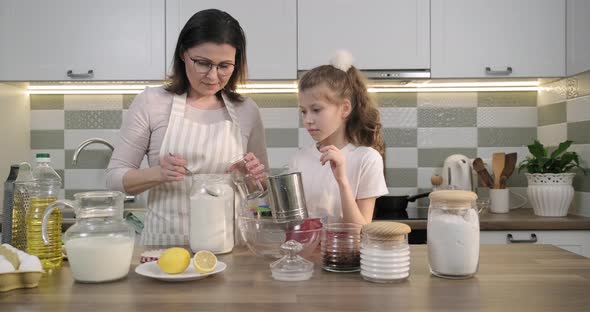 Mother and Child Preparing Bakery Together in Home Kitchen