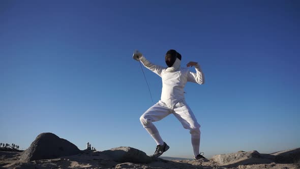 A man and woman fencing on the beach