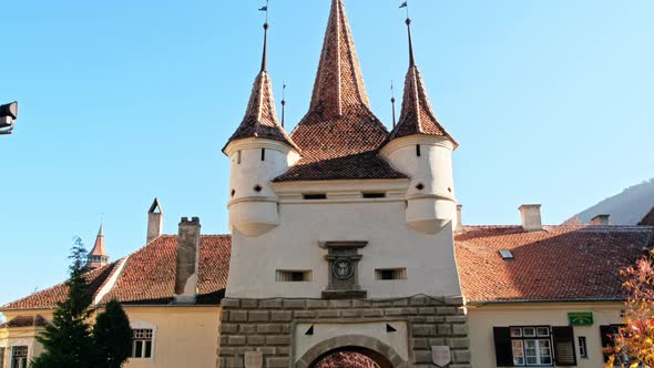 View of The Catherine's Gate in Brasov, Romania. Yellowed greenery and people in front of it