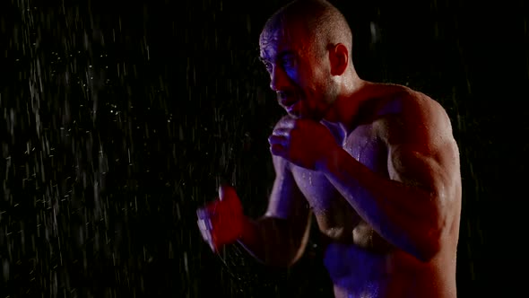 Boxer is Attacking Imaginary Enemy Fighting in Rain in Dark Night Epic and Dramatic