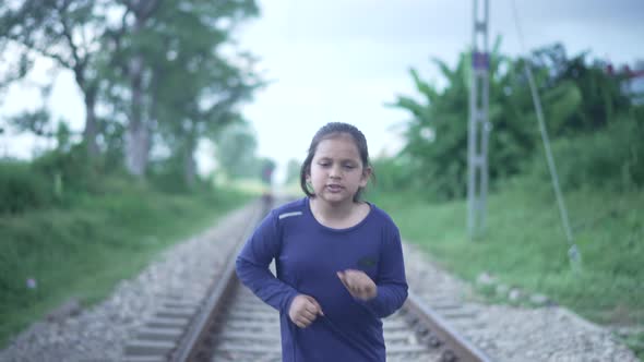 Slowmotion Shot of an Indian Kid Running on the Railway Track in the Himalayan Range of India