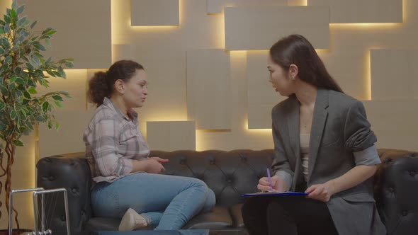 Worried Woman Having Counseling Session with Female Psychotherapist at Office