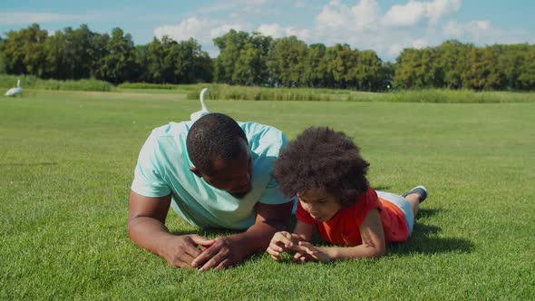 African Father with Cute Son Bonding on Park Lawn