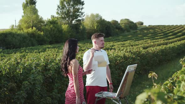 Artists' Couple Discusses About Surrounding Landscape Girl Smiles at Camera