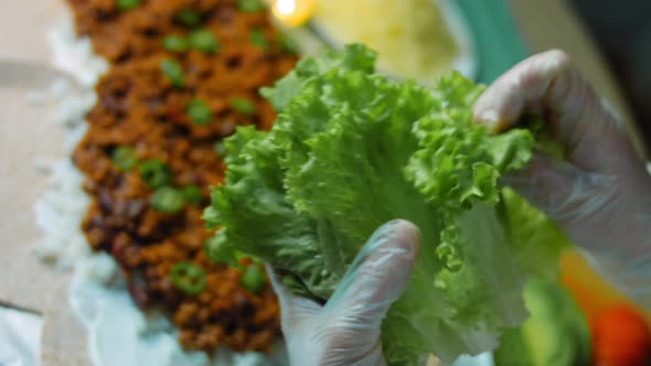 The Cook Puts Fresh Lettuce Leaves Over the Burrito