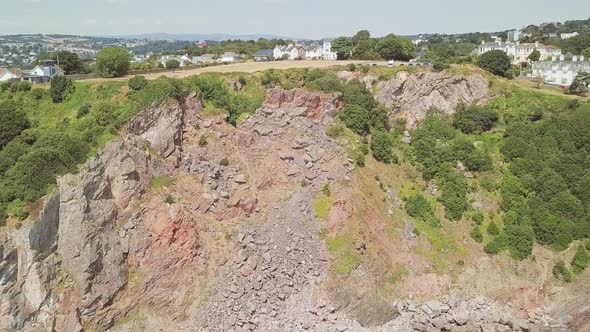 Aerial shot towards huge Cliffside, over seeing small Town.