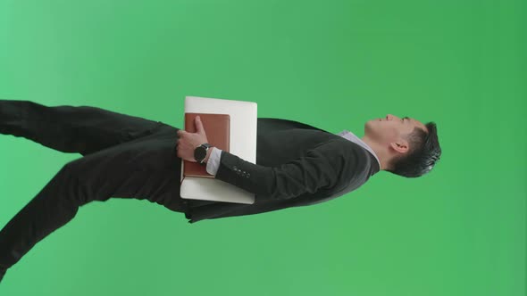 Side View Of Asian Business Man Holding Book And Document While Walking On Green Screen Chroma Key