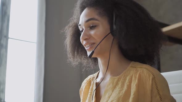 Smiling African American Woman with Headset Using Laptop, Talking, Working Customer Support Service