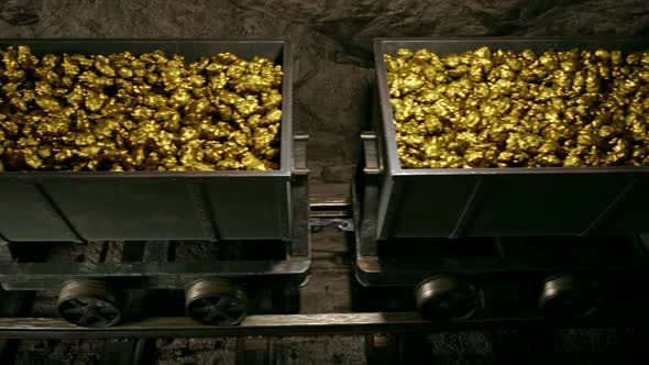 Top of a gold mine wagons slowly moving through narrow underground tunnel.