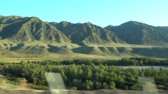 View of the green hills, trees from the car window. Travel to Kazakhstan. 