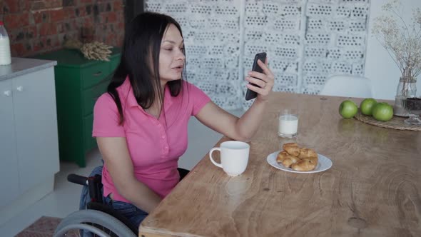 Young Woman in Wheelchair Talking with Friends Using Internet Ca