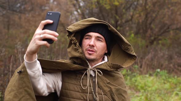 Portrait of Exhausted Tourist Male Wearing Tent Raincoat Getting Signal Making Video Call or