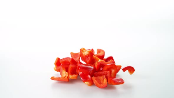 Super Slow Motion Shot of Falling and Slicing Red Pepper on White Background at 1000Fps