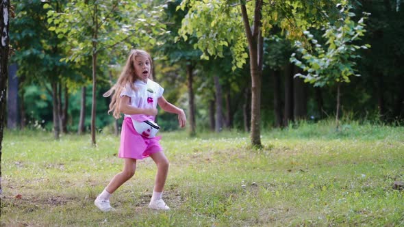 Girl dancing outdoors in park. Little blonde girl dancing in green park