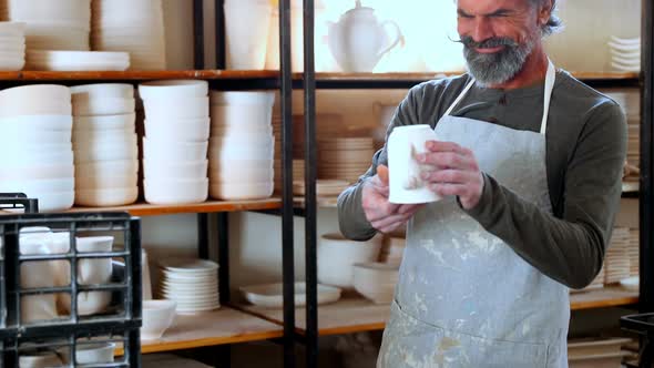 Male potter checking ceramic bowl