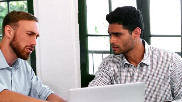 Businesspeople discussing over laptop