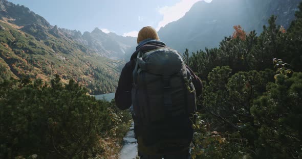 Male Hiker Backpacker Walking Stone Trail to Beautiful Mountain Lake Overlooking Incredible