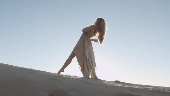 Graceful And Beautiful Woman Dancing On Sunny Sand