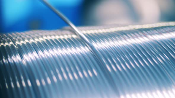 Shiny Silver Electrical Wire Unwinding From a Spool