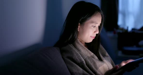 Woman use of tablet computer at night