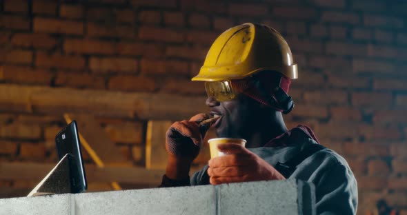 Black Builder Making Video Call During Lunch Break