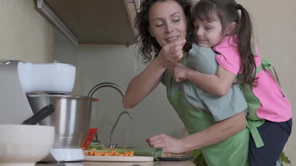 Family activity in the kitchen. A young housewife cuts a lettuce.