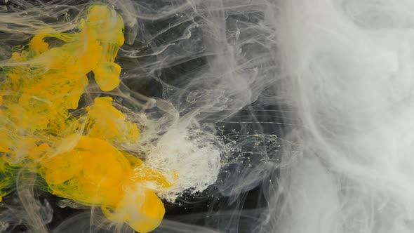 Dissolution of Yellow Paint in White Smoke on a Black Background