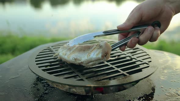 Man Put Hake Fish on the Grill