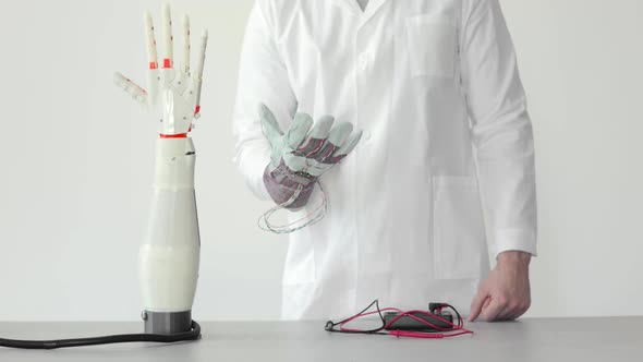 Engineer Is Testing Robotic Prosthesis Hand Which Repeats the Movement of His Hand in Glove with