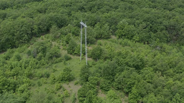 Above electric transmission construction in the forest 4K aerial footage