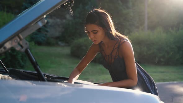 Young Woman Driver Standing Near Her Car with Open Hood