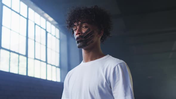 Portrait of african american man with hand mark on their mouth standing in empty parking garage