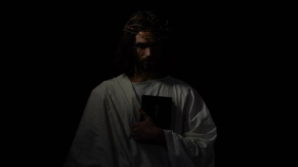 Man in Crown of Thorns Holding Bible Looking Directly, Jesus Before Crucifixion