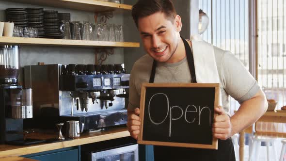 Happy owner with chalkboard at counter