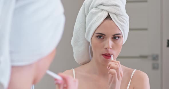 Young Female Stands in Front of the Mirror in Her Bathroom and Brushing Her Teeth, Care of the Oral