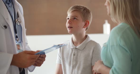 Cropped Shot of Pediatrician with Clipboard Consulting Mother with Teenage Son