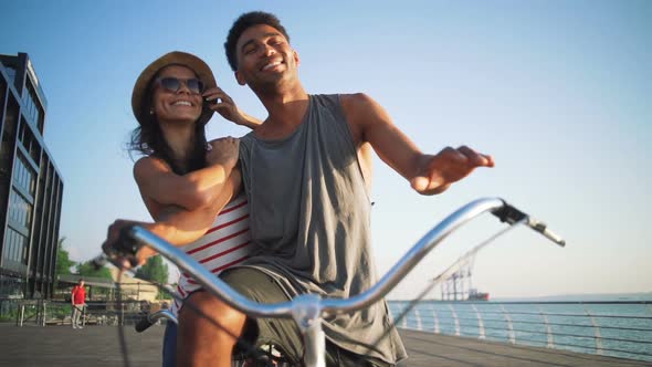 Portrait of a Mixed Race Couple on Tandem Bicycle Outdoors Near the Sea Slow Motion
