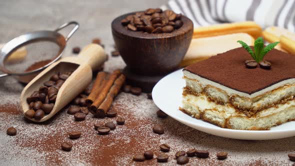 Portion of Traditional Italian Tiramisu dessert, coffee beans and savoiardi cookies