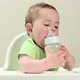 Baby boy sitting in highchair with bottle of milk - VideoHive Item for Sale