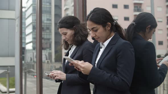 Focused Businesswomen Using Smartphones