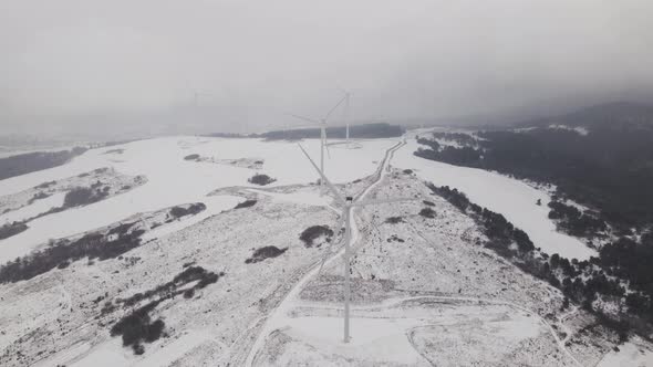 Aerial View of a Wind Farm in Winter Rotating Turbines on a Snowy Field in Ukraine