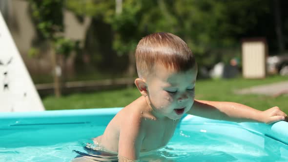 Caucasian Baby Child Kid Boy Having Fun in Pool in Backyard Outdoors Sunny Day